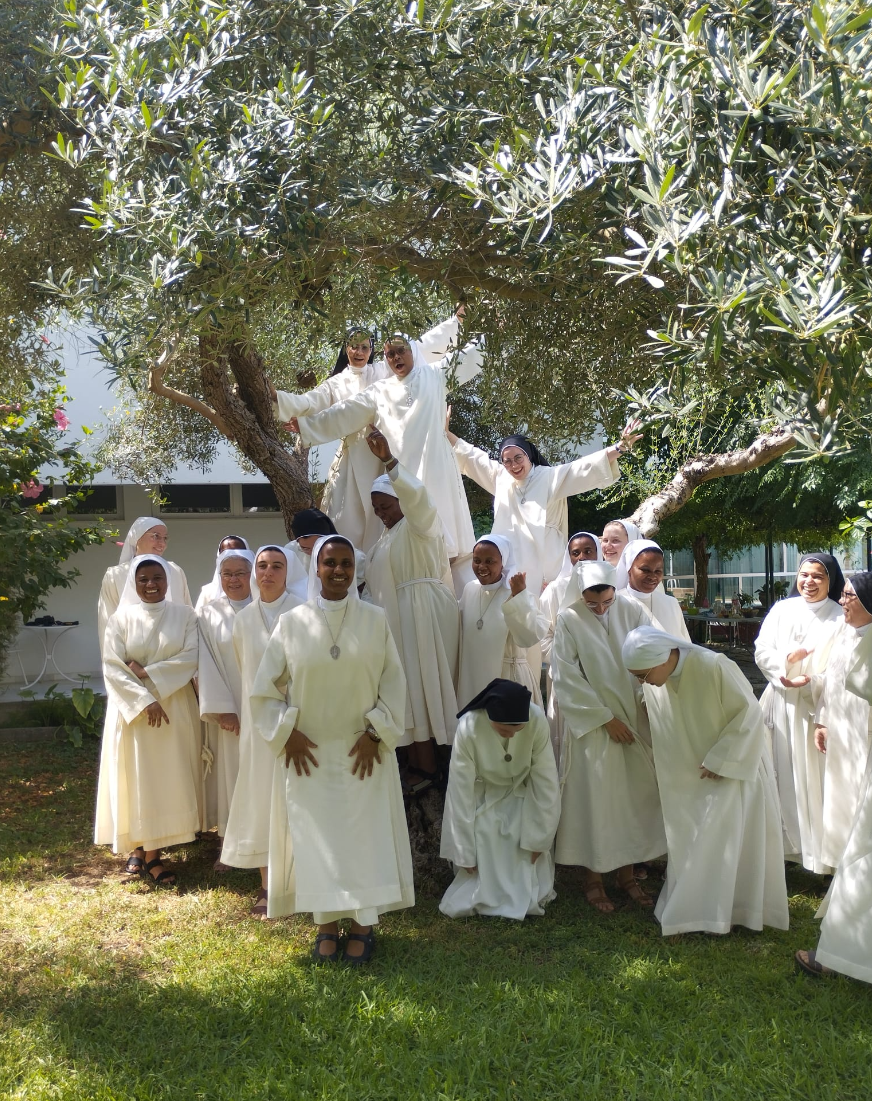 Jovens irmãs concepcionistas reunidas e sorridentes no jardim do mosteiro